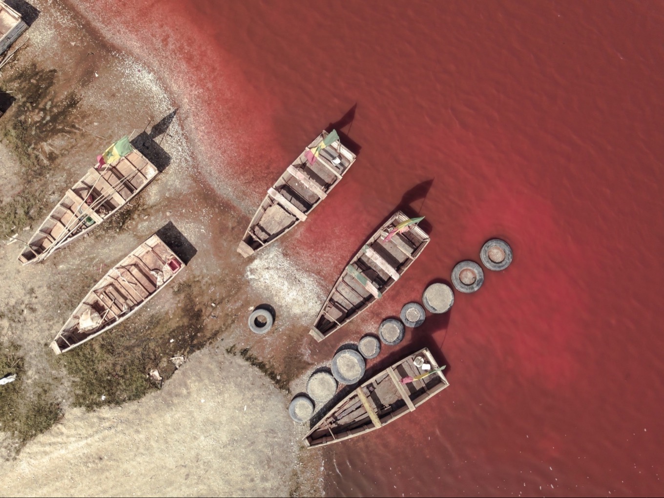 Bord du Lac Retba en décembre 2025 avec pirogues de pêcheurs de sel